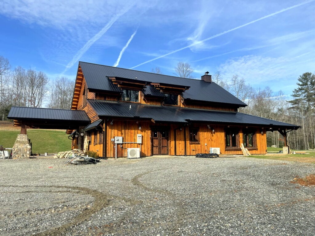 Converted barn exterior at the Blairsville Wedding Venue, timber cladding and black metal roof in afternoon sun.